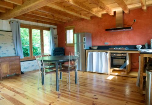 cocina con mesa y sillas en una habitación en Maison d'une chambre avec piscine partagee jardin clos et wifi a Gembrie, en Gembrie