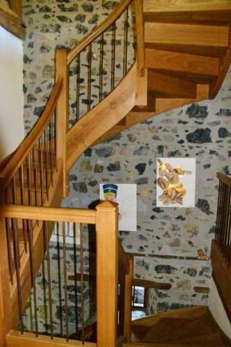 a wooden staircase with wooden railings in a room at Maison charmante à Gembrie + Piscine partagée & vue montagne in Gembrie