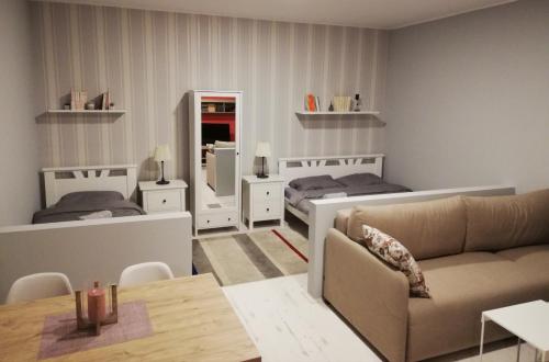 ein Wohnzimmer mit 2 Betten und einem Sofa in der Unterkunft Apartman Park in Subotica