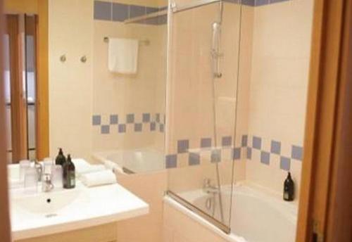Un baño con lavabo, ducha y bañera. en Aparthotel XV Porte Versailles 2P 4 Pers Parking, en París