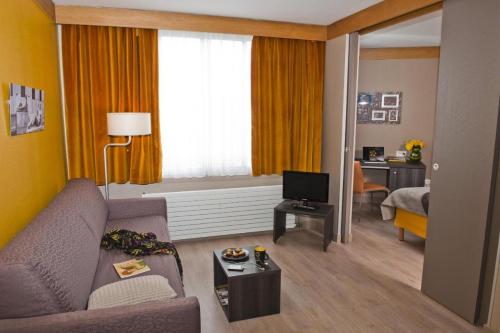 sala de estar con sofá y dormitorio en Aparthotel XV Porte Versailles 2P 4 Pers Parking, en París