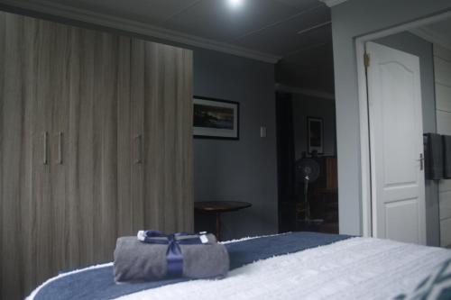 a bedroom with a bed with a blue ribbon on it at Aloe Ocean Flatlet in Bettyʼs Bay