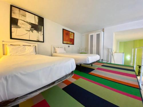 een kamer met 2 bedden en een kleurrijk tapijt bij Charming Madrid Río II in Madrid