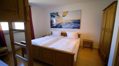 a bedroom with a bed with a picture on the wall at Gästehaus am Wasserpark in Rust