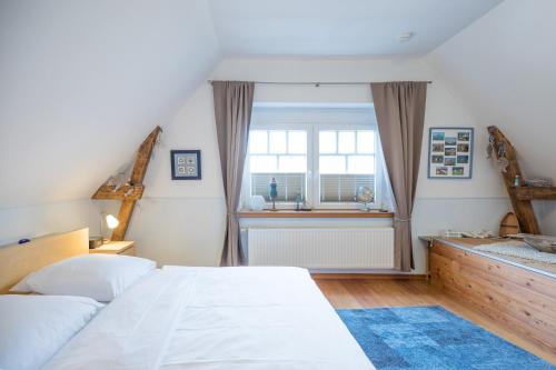 Un dormitorio con una gran cama blanca y una ventana. en Villa-Husum, en Husum