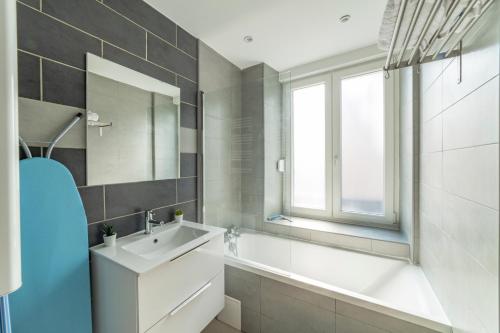 een badkamer met een wastafel, een spiegel en een bad bij ❂ LES ROCHES ❂ CHIC ❂ CENTRE ❂ 6 PERS. ❂ RDC ❂ RBNB ❂ in Mulhouse
