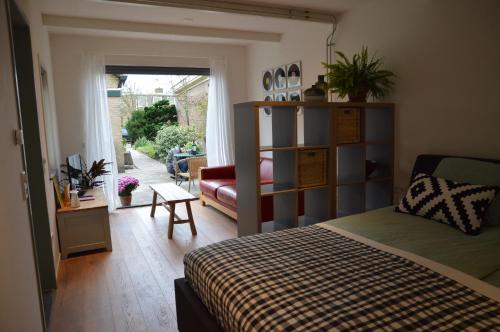 a bedroom with a bed and a living room at Cosy Casa in Egmond aan Zee