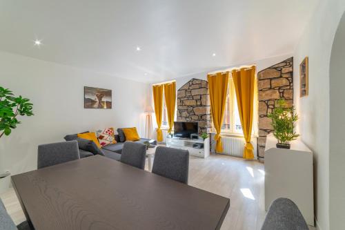 een woonkamer met een tafel en gele gordijnen bij ❂ LES ROCHES ❂ CHIC ❂ CENTRE ❂ 6 PERS. ❂ RDC ❂ RBNB ❂ in Mulhouse