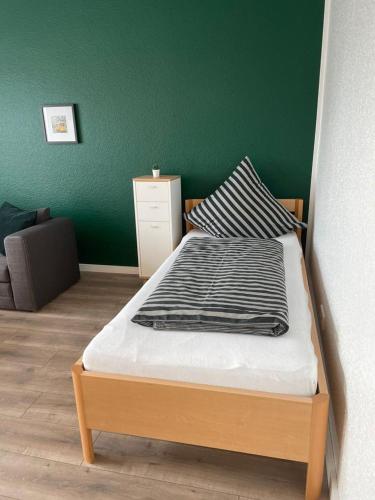 a bed in a room with a green wall at Cityapartment in Stadtlohn