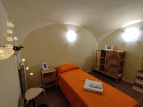 a bedroom with an orange bed and a table and chair at Rega Holiday House in Naples