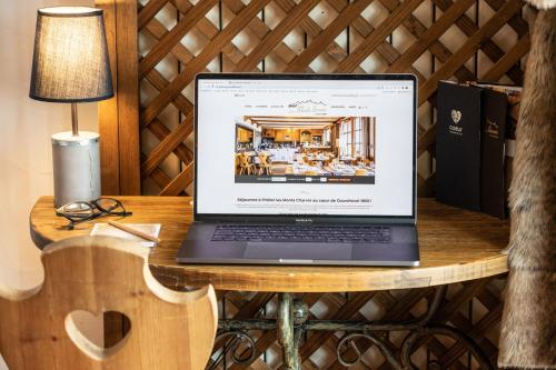 a laptop computer sitting on a wooden table at Les Monts Charvin in Courchevel