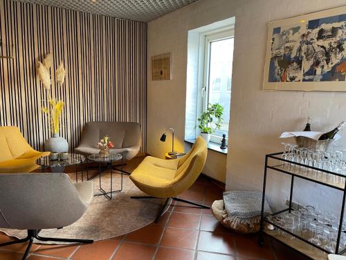 a living room with yellow chairs and a table at City Hotel Nattergalen in Odense