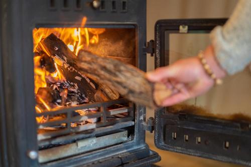 a person is cooking food in an oven at AfriCamps at Gowan Valley in Balgowan