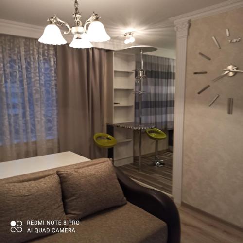 a living room with a couch and a clock on the wall at Апартаменты на Московском проспекте in Kaliningrad