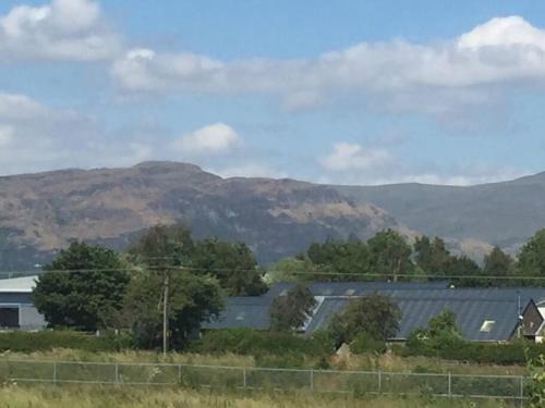 vistas a las montañas y a una casa con valla en Castle View - Home from Home en Stirling