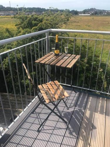 a bottle of wine sitting on a table on a balcony at Castle View - Home from Home in Stirling