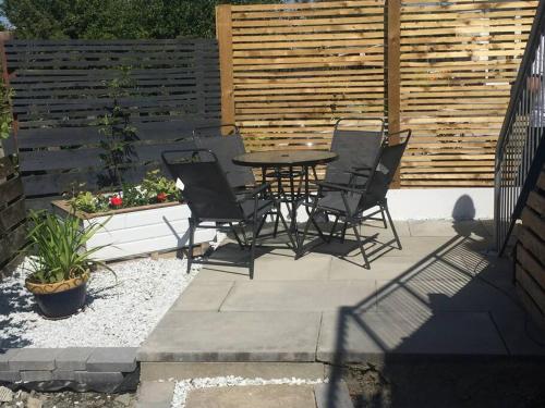 een patio met een tafel en stoelen en een hek bij Castle View - Home from Home in Stirling