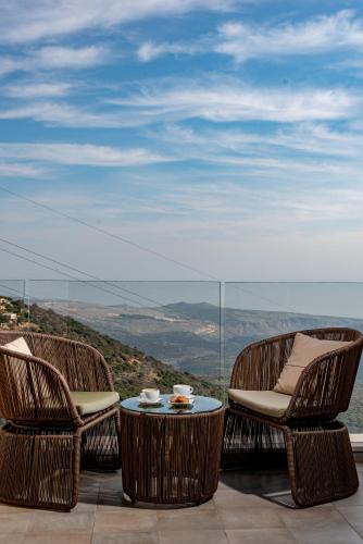 two chairs and a table on a balcony with a view at Amirey Hagalil Boutique Hotel in Amirim