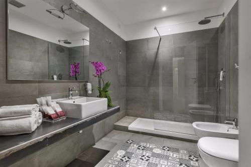 a bathroom with a sink and a toilet and a shower at DA ME Suites in Rome