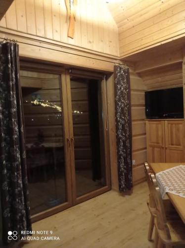 a sliding glass door in a room with a dining table at Pokoje ,,Goramiba''Jurgów in Jurgów