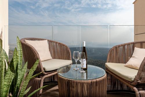 a table with two chairs and a bottle of wine at Amirey Hagalil Boutique Hotel in Amirim