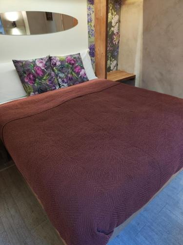 a bed with a red comforter and pillows at Il Pozzo di Santa Zita in Lucca