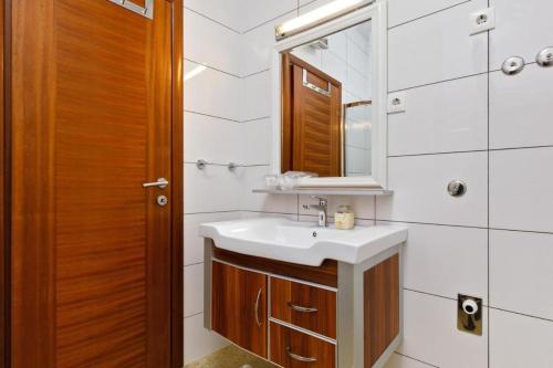a bathroom with a sink and a mirror at Ark Beach Apartments next to the beach in Stobrec in Split
