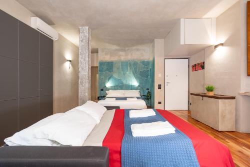 una grande camera da letto con due letti e un divano di Il Garbo Apartments and Suite a Verona