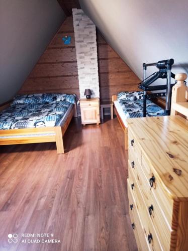 a attic bedroom with two beds and wooden floors at Pokoje ,,Goramiba''Jurgów in Jurgów