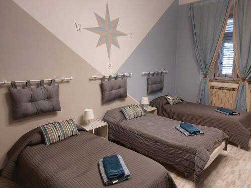 a room with three beds and a star on the wall at B&B Empire 1970 in Trieste
