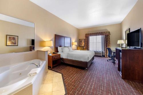 una camera d'albergo con letto, vasca e TV di Comfort Inn & Suites Shawnee North near I-40 a Shawnee