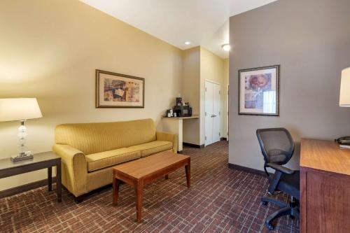 a living room with a couch and a desk and a chair at Comfort Inn & Suites Shawnee North near I-40 in Shawnee