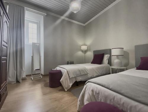 ein Schlafzimmer mit zwei Betten und einem Fenster in der Unterkunft Além do Mar Apartment - RRAL n. 3214 in Ribeira Grande