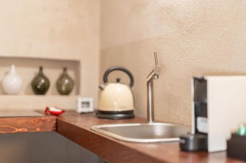 un bancone della cucina con un lavandino con un bollitore sopra di Il Garbo Apartments and Suite a Verona