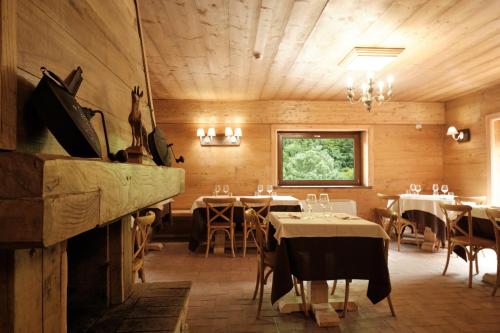 restauracja ze stołami i krzesłami oraz kominkiem w obiekcie HOTEL CAMPO STELLA w mieście Leonessa