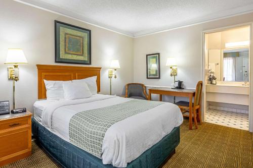 Pokój hotelowy z łóżkiem i biurkiem w obiekcie Rodeway Inn w mieście Huntsville