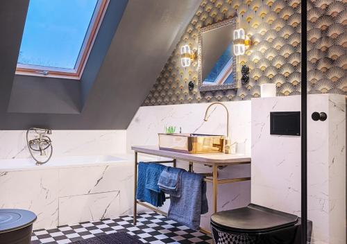La salle de bains est pourvue d'un lavabo et d'une coiffeuse avec un miroir. dans l'établissement Rezydencja Julin Slow Life dla Gości 16+, à Wydrze