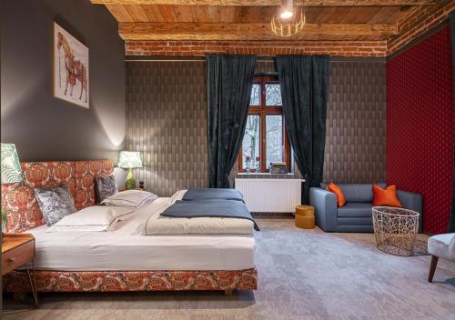 a bedroom with a large bed and a couch at Rezydencja Julin Slow Life dla Gości 16+ in Wydrze
