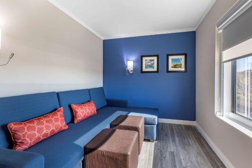 a living room with a blue couch and red pillows at Comfort Suites St Louis - Sunset Hills in Saint Louis