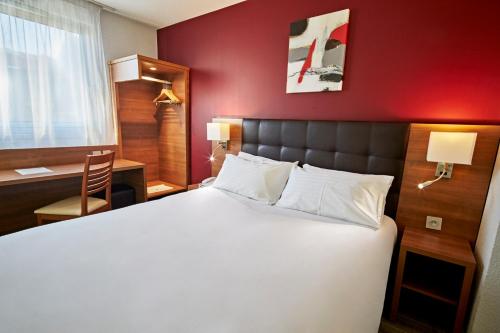 une chambre avec un grand lit blanc avec un mur rouge dans l'établissement Holiday Inn Clermont Ferrand Centre by IHG, à Clermont-Ferrand