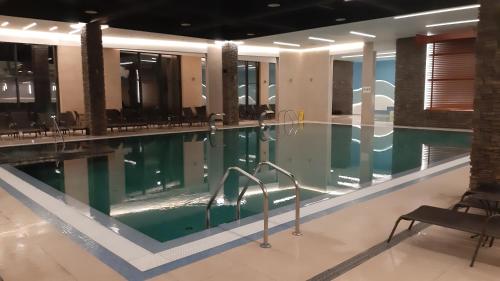 a swimming pool with chairs in a building at Zlatiborski konaci k17 i K19 in Zlatibor