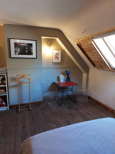 a attic room with a table and a window at Gery Art Gallery in Namur