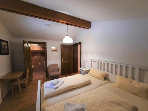 a bedroom with two beds and a table and a desk at Zwischen Mozart und König Ludwig in Teisendorf