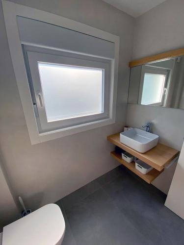 a bathroom with a white sink and a mirror at Apartamentos Angelito Playa América A in Nigrán