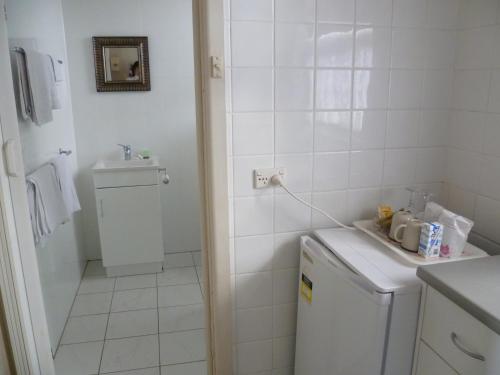 a small white bathroom with a sink and a washing machine at Mount View Motel in Mount Gambier