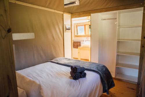 a small bedroom with a bed and a closet at AfriCamps at Mackers in Hazyview