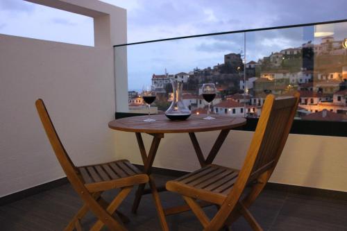 uma mesa com duas cadeiras e dois copos de vinho em Berna Apartment em Funchal