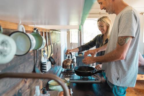 a man and woman preparing food in a kitchen at AfriCamps at Mackers in Hazyview