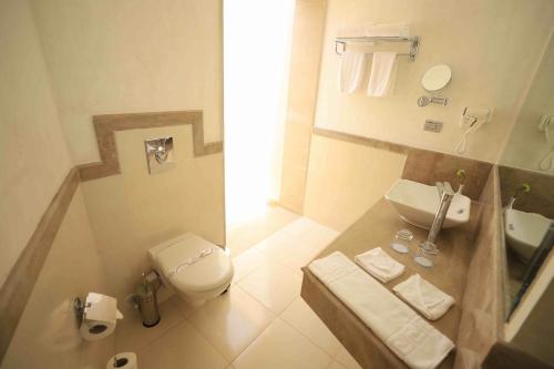 a small bathroom with a toilet and a sink at Shams Lodge in Hurghada