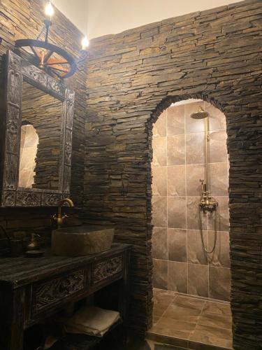 a stone bathroom with a sink and a shower at Superb Medieval Apartment in Kutná Hora